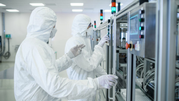 Team of Scientists in Sterile Protective Clothing Work on a Modern Industrial 3D Printing Machinery. Pharmaceutical, Biotechnological and Semiconductor Creating / Manufacturing Process.